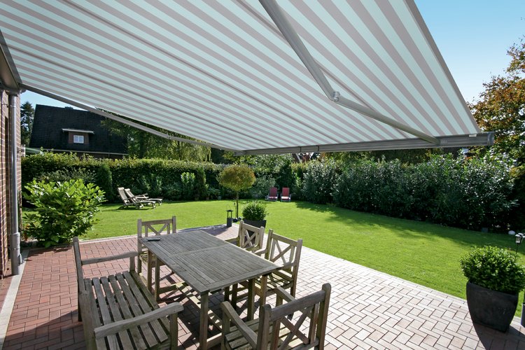 helle gestreifte Markise über Tisch und Stühlen