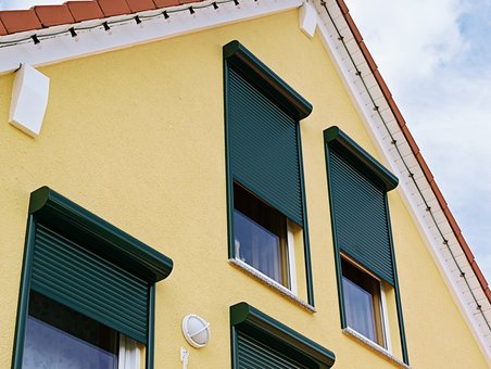 gelbes Haus mit grünen Rolläden