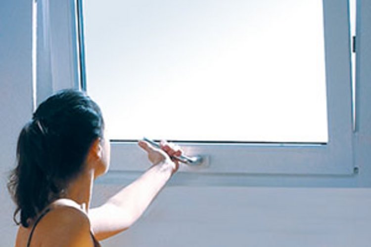 eine Frau schließt ein Fenster